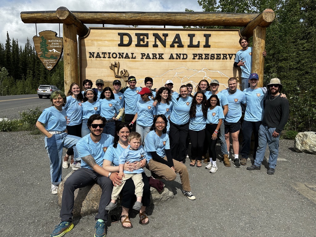 Volunteer team gathered in front of the Denali National Park sign