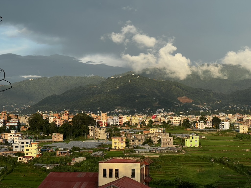 A Nepalese town beneath green mountains and low clouds